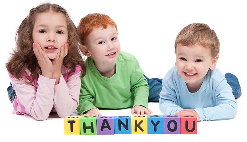 Children behind blocks that spell out Thank You